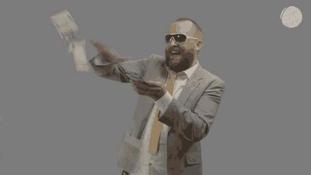 a man in a suit and tie is holding a cell phone and throwing money in the air
