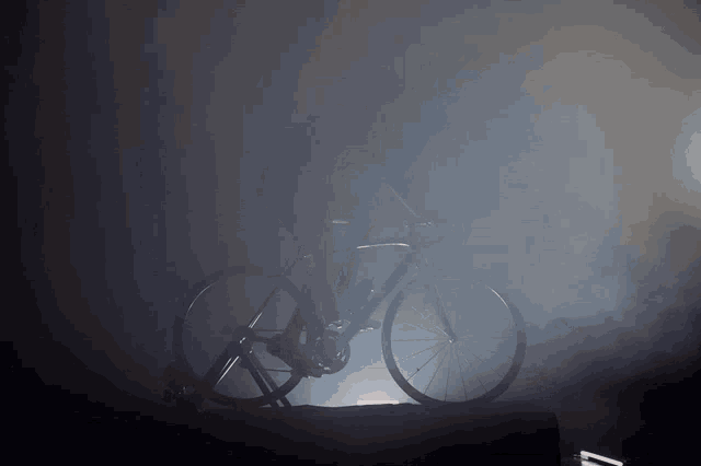 a bicycle is silhouetted against a dark background