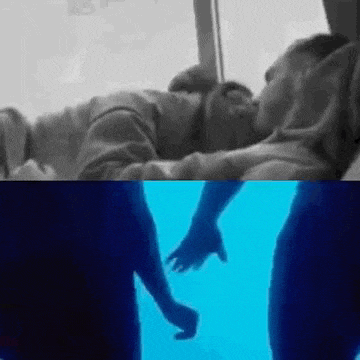 a man is kissing another man on the cheek in a black and white photo while holding his hand .