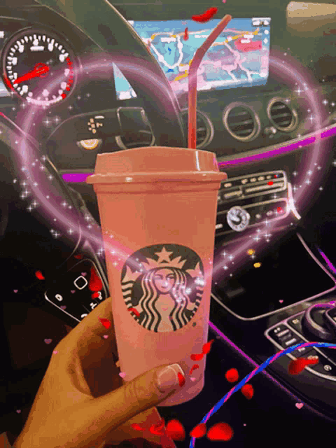 a person is holding a pink starbucks cup with a red straw