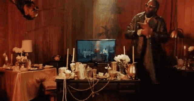 a man is standing in front of a table with a tv on it