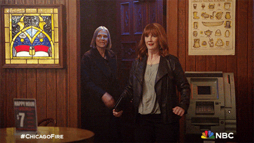 two women shaking hands in front of a stained glass window with the hashtag #chicagofire