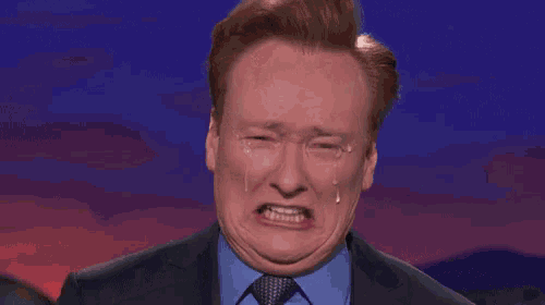 a man in a suit and tie is crying with tears coming out of his eyes