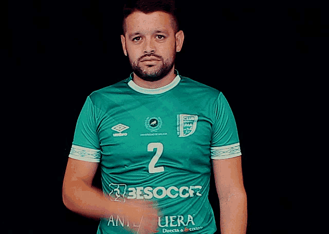 a man wearing a green jersey with the number 2