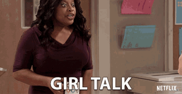 a woman in a purple shirt says girl talk in front of a netflix machine