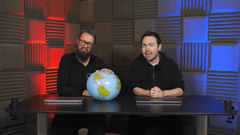 two men are sitting at a table with a globe on it