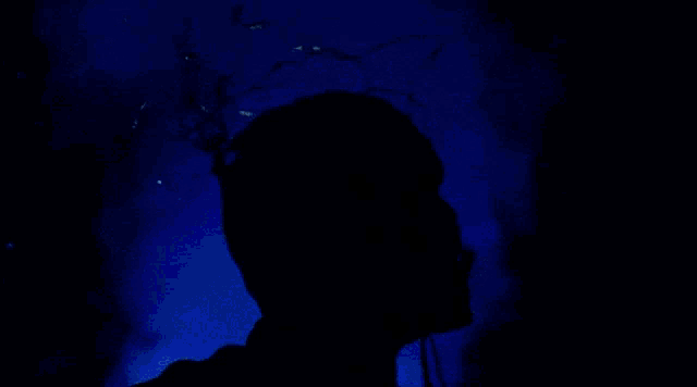 a monster with headphones on his head looks up at the sky