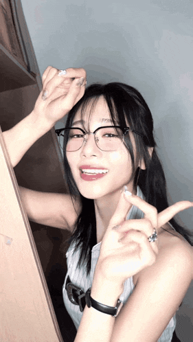 a woman wearing glasses and a watch is smiling