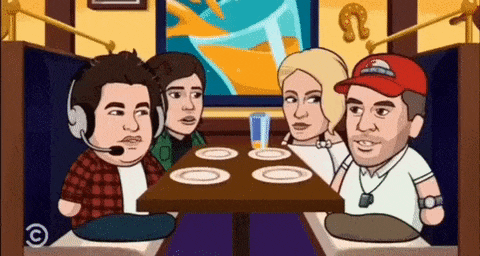 a group of people are sitting at a table with plates and a glass of orange juice .