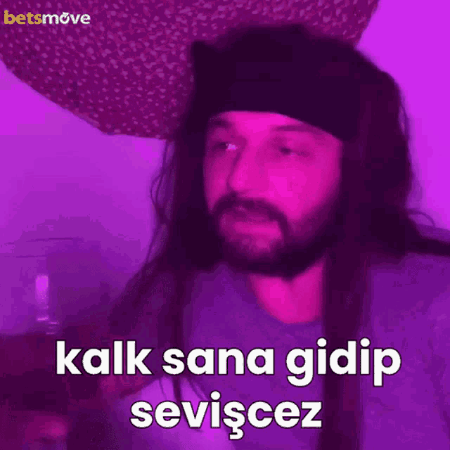 a man with long hair and a headband says kalk sana gidip seviyez