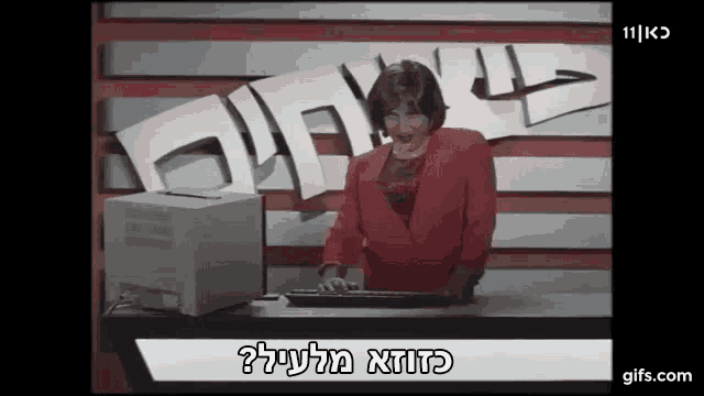 a woman in a red jacket is typing on a keyboard in front of a computer screen that says " gifs.com "