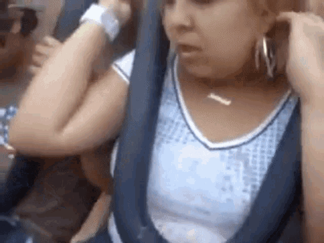 a woman is sitting on a roller coaster wearing a life jacket .