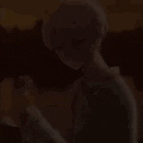a boy is holding a flower in his hand and looking down .