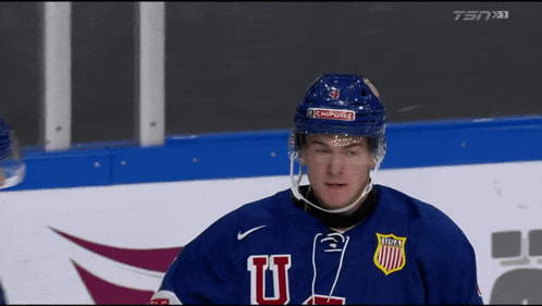 a hockey player wearing a blue jersey with the letters u on it