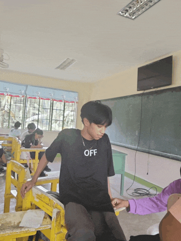 a boy wearing a black shirt that says off
