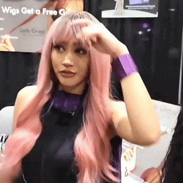 a woman wearing a pink wig and purple wristband