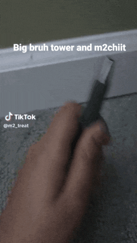 a person is holding a pencil with the caption big bruh tower and m2chiit on the bottom