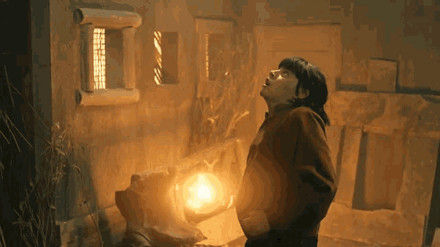 a woman in a dark room holding a light in her hand