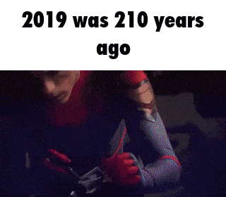 a man in a spiderman suit is looking at the camera with the words `` 2019 was 210 years ago '' written above him .
