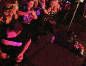 a man playing a guitar in front of a crowd of people