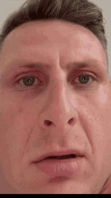 a close up of a man 's face with a slight smile on his face