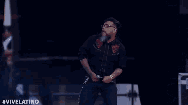 a man is dancing in front of a camera with the hashtag #vivelatino on the bottom