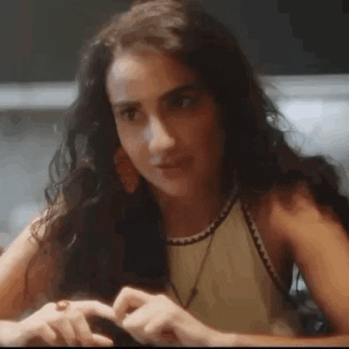 a woman is sitting at a table with a cell phone in her hand .