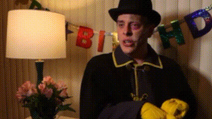 a man in a top hat is standing in front of a sign that says birthday .