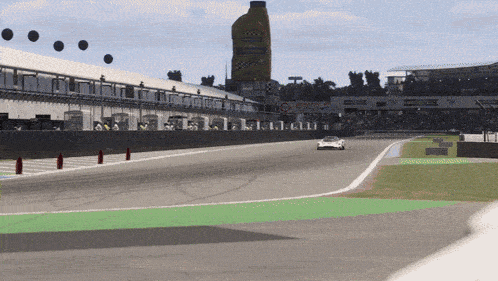 a race car is driving down a race track with a large bottle of ravenol behind it