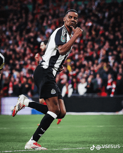 a soccer player wearing a black and white jersey with the word newcastle on it is running on the field
