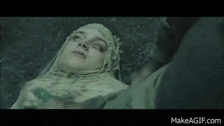 a woman in a veil is laying on the ground with a man standing next to her .