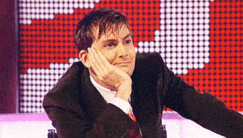 a man in a suit and tie rests his hand on his chin