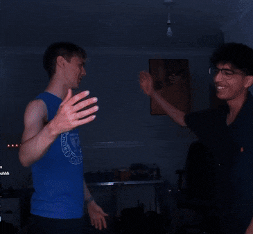a man wearing a blue shirt that says " let 's party " holds hands with another man