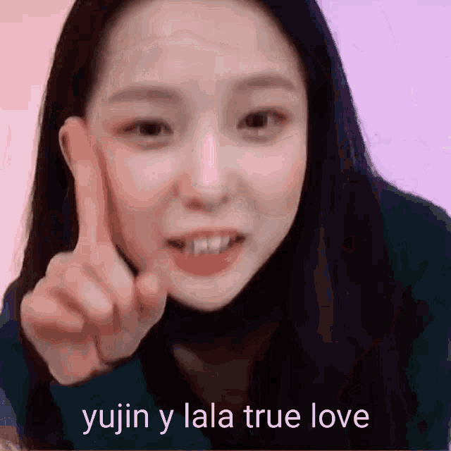 a woman is pointing at the camera with the words yujin y lala true love behind her