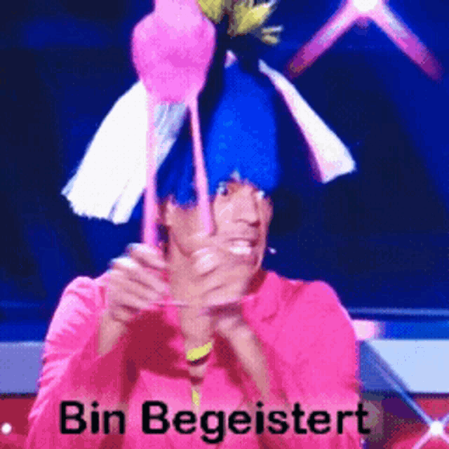 a man wearing a pink shirt and a blue hat with the words bin begleitert on the bottom