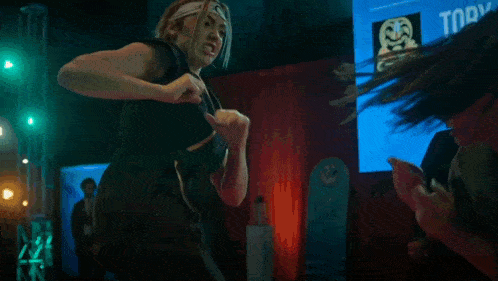 a group of people are dancing in a dark room with green lights