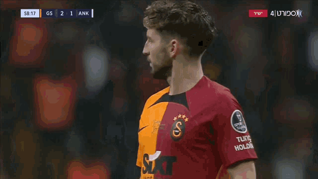 a soccer player wearing a shirt that says tutco holding