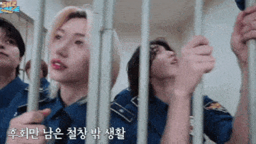 a group of police officers are behind bars in a prison cell .