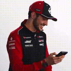 a man wearing a red and black hat is looking at his cell phone .