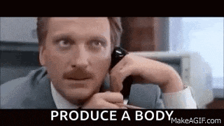 a man in a suit is talking on a cell phone .