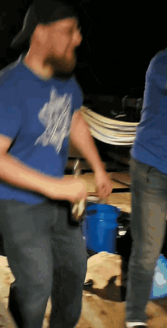 a man wearing a blue shirt with a cat on it