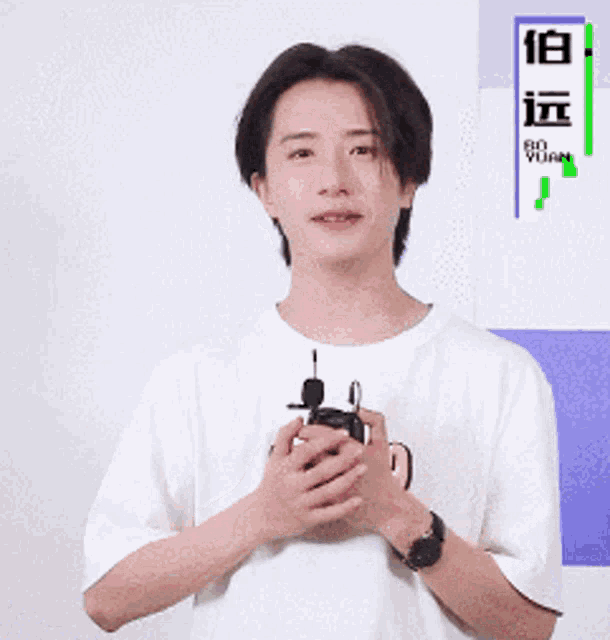 a man in a white shirt holds a microphone in his hands