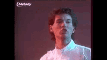a man is singing into a microphone in a video .