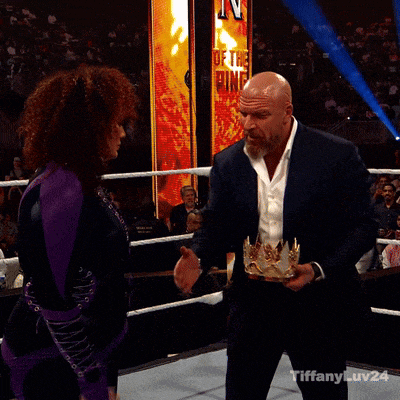 a man is hugging a woman in a wrestling ring with a sign behind them that says death ring