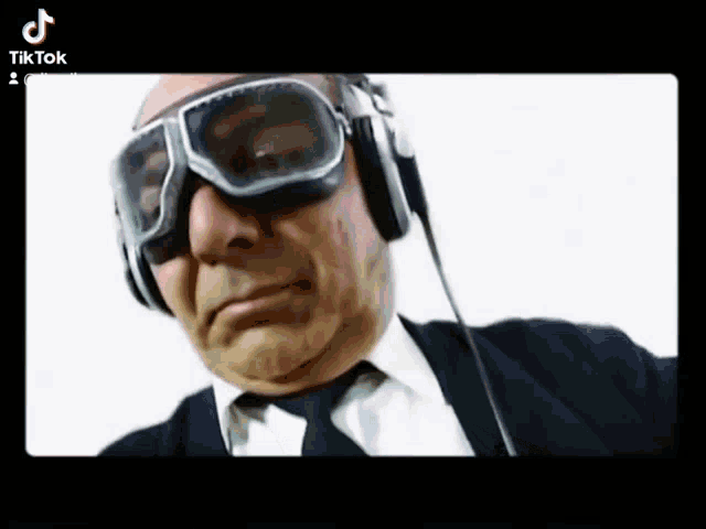 a man wearing goggles and headphones has a tiktok logo on the bottom left