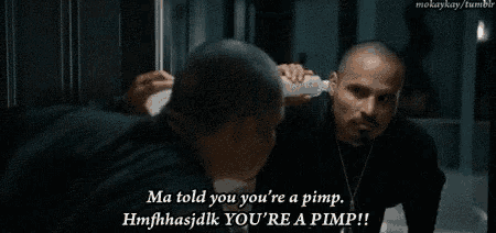 a man in a black shirt is talking to himself in the mirror