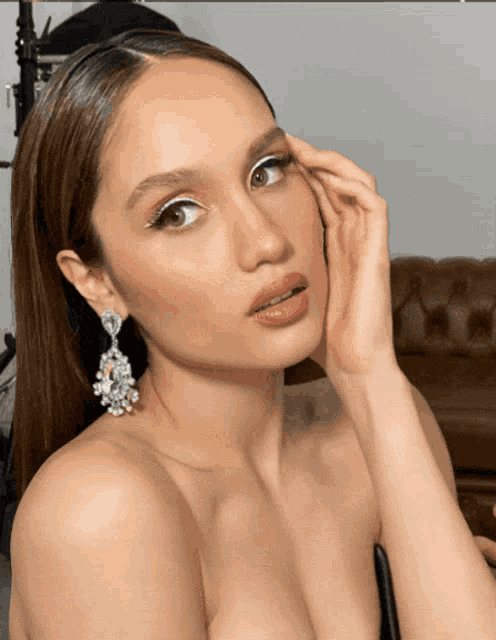 a close up of a woman 's face wearing earrings