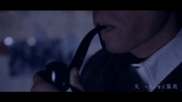 a man in a suit and tie smoking a pipe with chinese writing on the bottom
