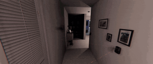 a dark hallway with a few pictures on the wall and a lamp