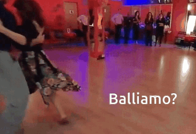a group of people are dancing in a dance studio with the words balliamo written on the floor